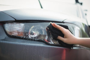 What To Do With Foggy Headlights Auto Body Shop | Collision Repair Experts – Fix Auto USA close up of someone cleaning a car headlight