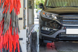 a car driving through an automatic car wash at a gas station